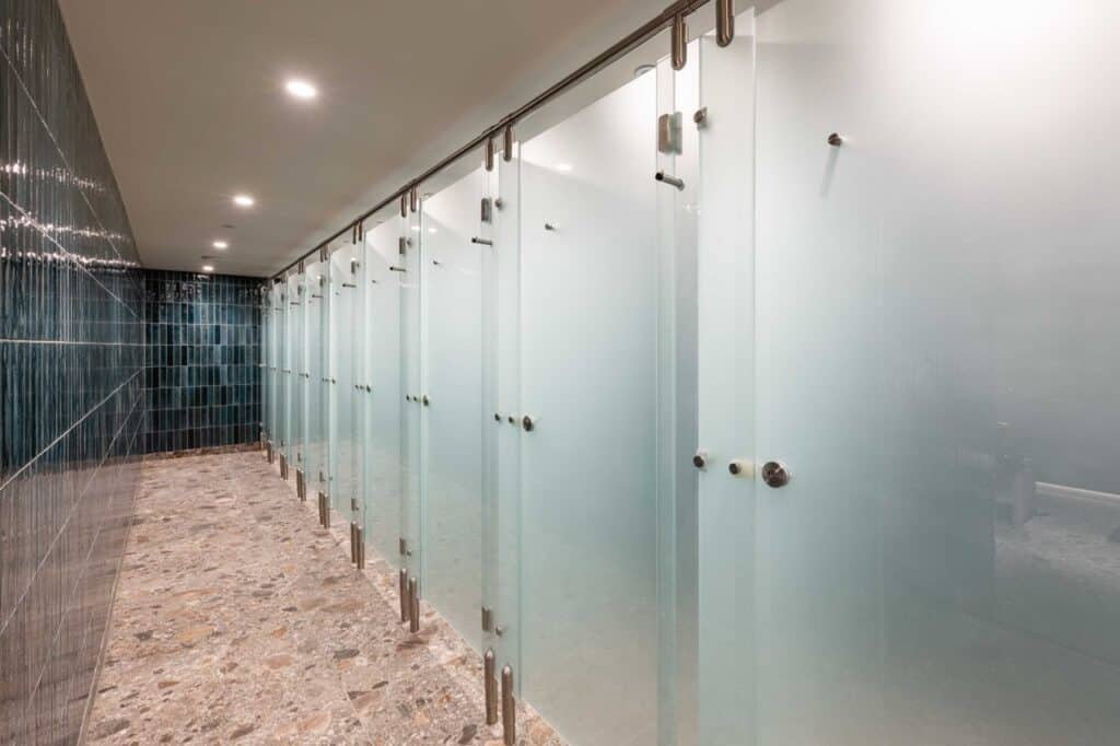 Row of Olympus Glass shower cubicles for gym washroom