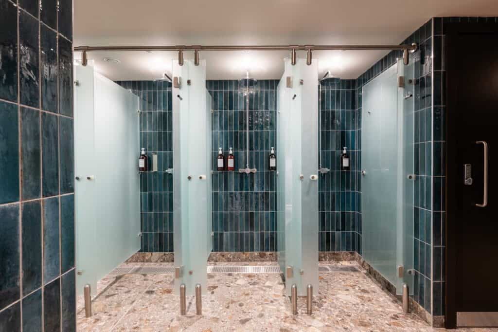 Row of open glass shower cubicles