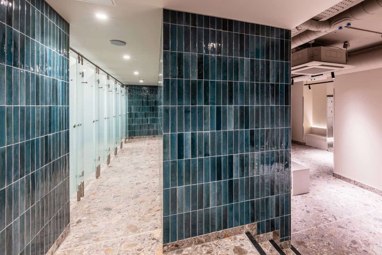 Large gym washroom area with Olympus Glass showers and Identity cubicles